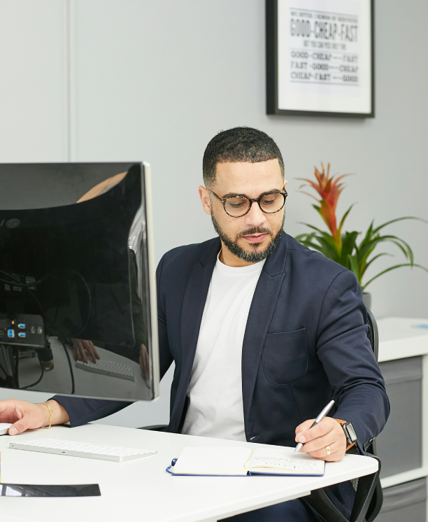 Business consultant working on financial reports at desk – A New Horizon Consulting